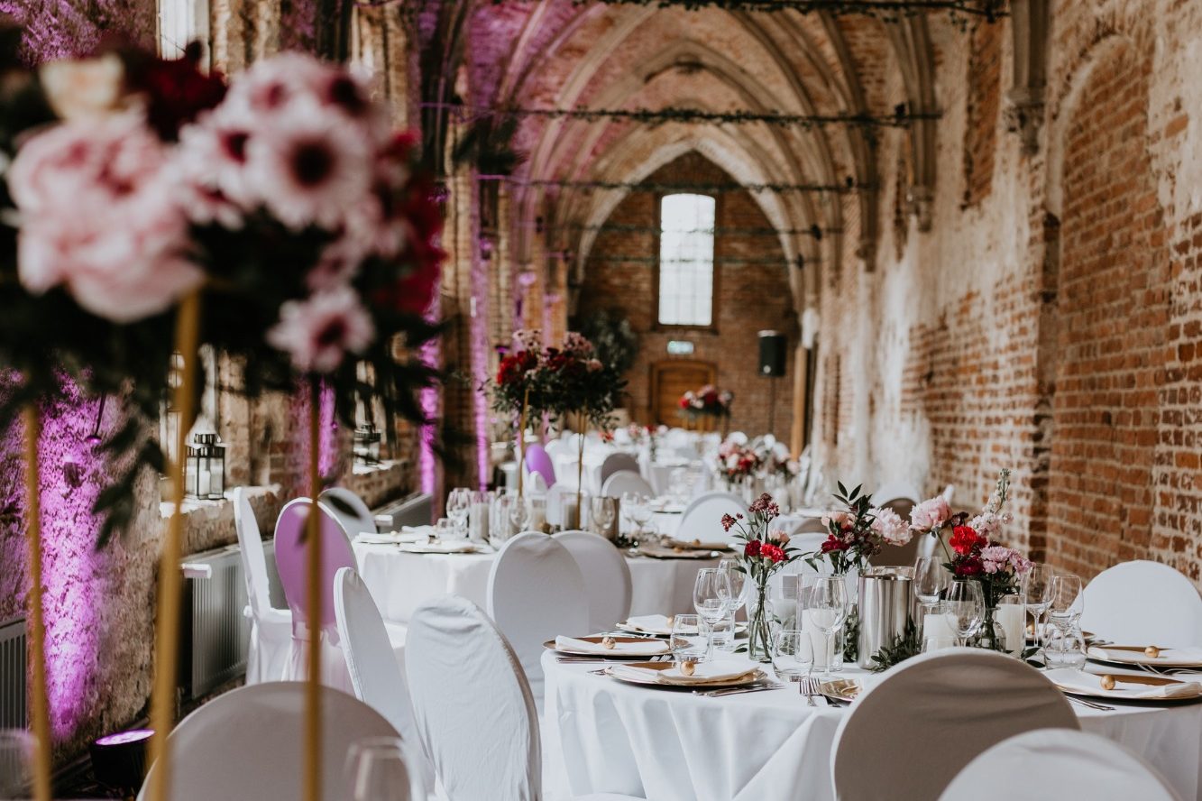 Dekorierte Hochzeitslocation in industriellem Stil mit rosaroten Farbakzenten