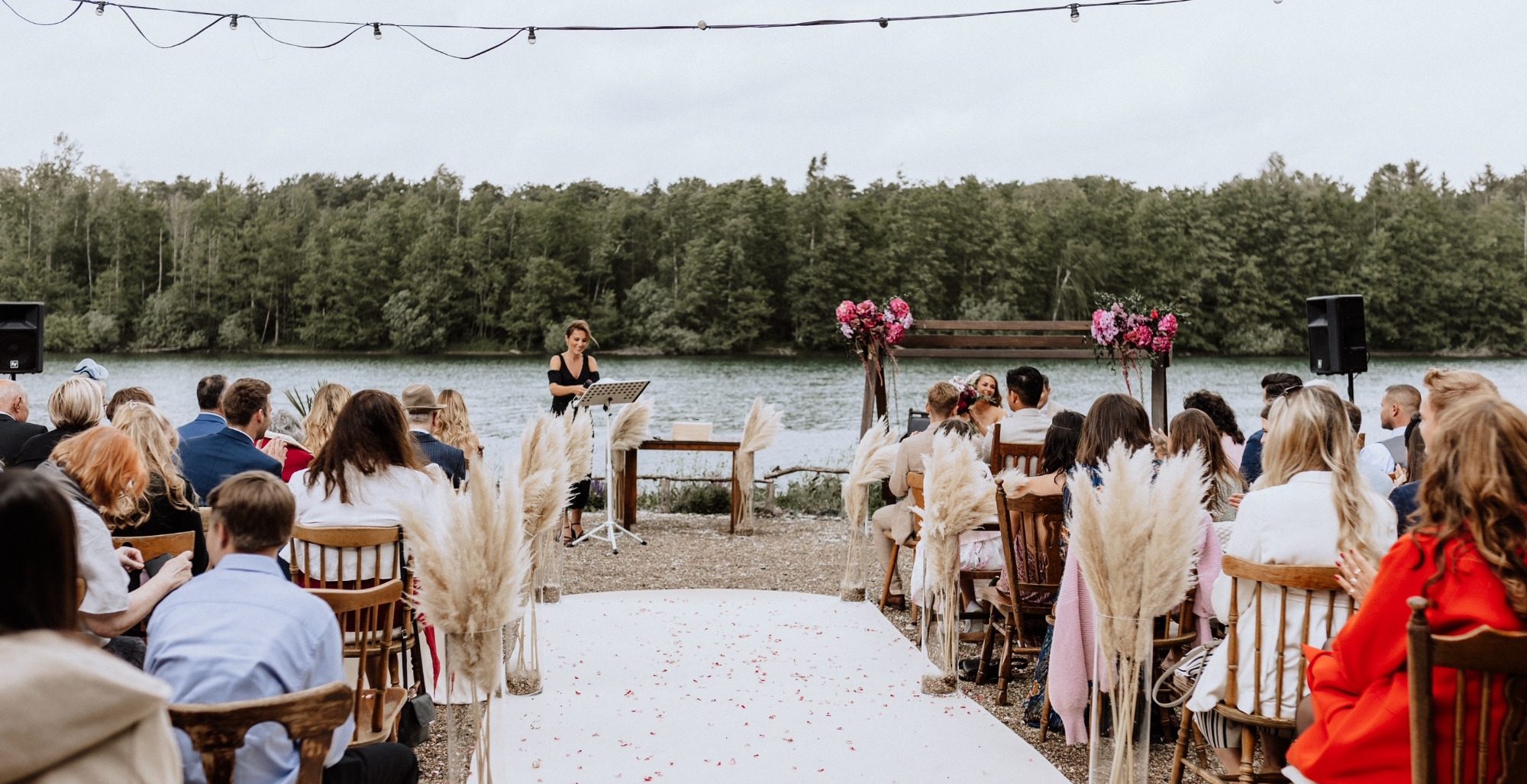 Traugemeinde sitzt vor dem Altar an einem See